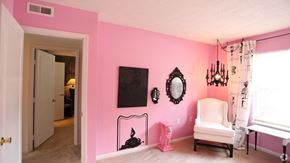 Columbus apartment for rent - a pink and white bedroom with a chair and a mirror
