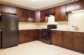 Clarkston apartment for rent - a kitchen with wooden cabinets and a black refrigerator