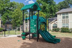 Clarkston apartment for rent - a playground with a slide and swing set in a park