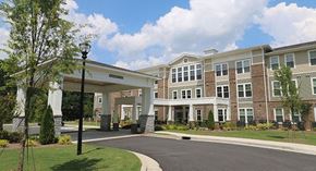Stone Mountain apartment for rent - an exterior view of a large building with a driveway and trees