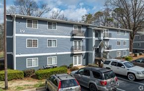 Stone Mountain apartment for rent - a blue apartment building with cars parked in a parking lot