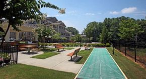 Atlanta apartment for rent - A green running track in a park with benches and trees.