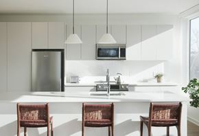 Philadelphia apartment for rent - a modern kitchen with white cabinets and a white island with three chairs