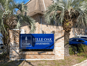 Metairie apartment for rent - A sign for Belle Oak Apartments is displayed in front of a building.
