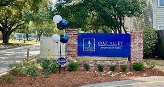 Terrytown apartment for rent - A sign for Oak Alley Apartments is adorned with balloons.