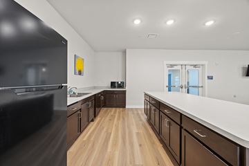 Garland apartment for rent - A kitchen with brown cabinets and a white counter.