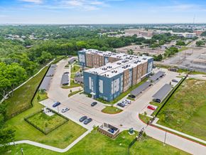 Garland apartment for rent - A large building with a parking lot in front of it.