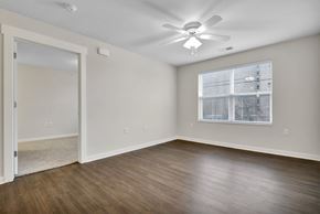 Lansing apartment for rent - A room with a ceiling fan and a window with blinds.