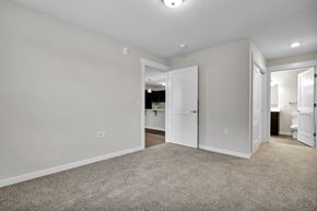 Lansing apartment for rent - A spacious room with white walls and a carpeted floor.