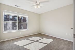 Grimes apartment for rent - A room with a ceiling fan and a window overlooking a building.