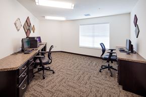 Newton apartment for rent - A carpeted office room with two desks and chairs.