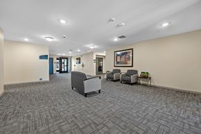 Cedar Rapids apartment for rent - A hallway with a carpeted floor and a few chairs and a table.