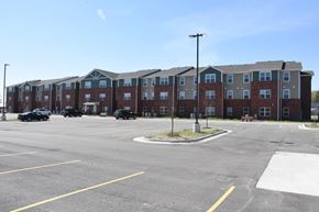 Muscatine apartment for rent - A parking lot in front of a large apartment complex.