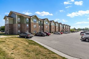Cedar Rapids apartment for rent - A row of apartment buildings with cars parked in front.