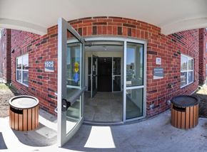 Muscatine apartment for rent - A brick building with a glass door and a sign that says 1925.