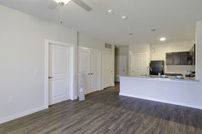 Dallas apartment for rent - A spacious living room with a white reception desk and a wooden floor.