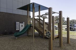 Dallas apartment for rent - A playground with a green slide and a wooden structure.