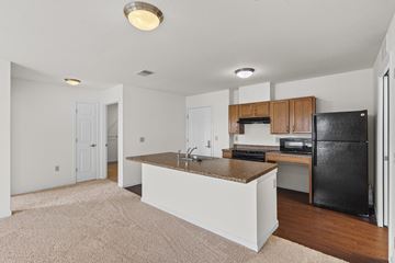Des Moines apartment for rent - A kitchen with white cabinets and a black fridge.