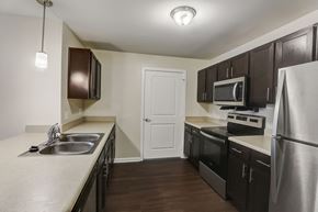 Atlanta apartment for rent - a kitchen with stainless steel appliances and dark wood cabinets