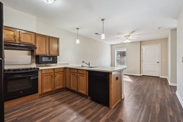 Grimes apartment for rent - A kitchen with wooden cabinets and a black oven.
