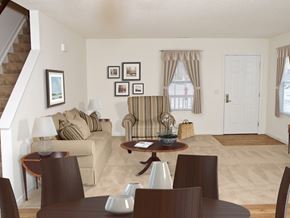 Altoona apartment for rent - A living room with a brown couch, a coffee table, and a staircase.
