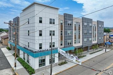Monaca apartment for rent - A large white building with a blue stripe on the bottom.