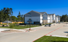 Lufkin apartment for rent - A parking lot in front of a building with a gazebo in the foreground.