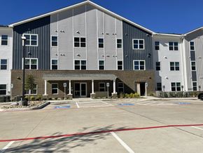 Lufkin apartment for rent - A large building with a parking lot in front.