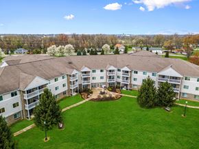 Dayton apartment for rent - A large white building with a brown roof surrounded by a green lawn.