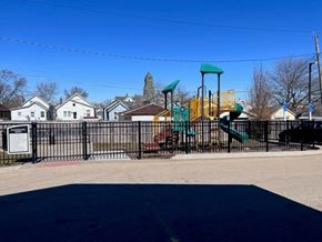 Clinton apartment for rent - A playground with a green slide and a sign in front of a house.