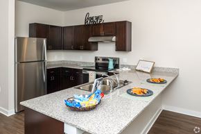 Palestine apartment for rent - A kitchen with a granite countertop and a refrigerator.