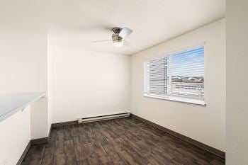 An empty living room with wood floors and a window