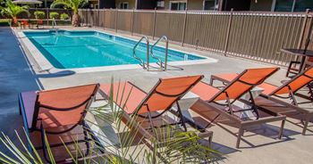 A pool with deck chairs and a poolside pool