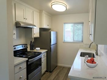A kitchen with stainless steel appliances and a white counter top 