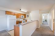 West Richland apartment for rent - a long kitchen with white appliances and a granite counter top  at Quail Springs, West Richland, WA, 99353
