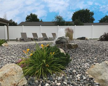 A water feature in a rock garden with rocks and plants
