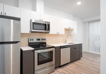 A kitchen with stainless steel appliances and white cabinets