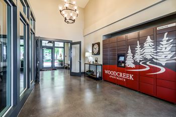 The lobby apartments with a reception desk and a wood creek partners sign
