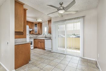 A kitchen with a sliding glass door leading to a balcony 