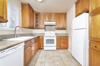 A kitchen with wooden cabinets and white appliances 