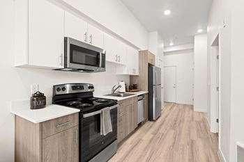 A kitchen with white cabinets and black appliances