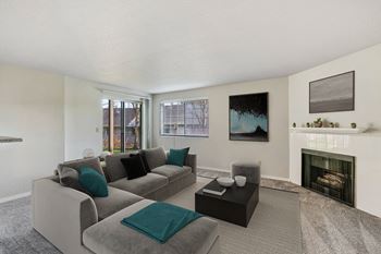 A living room with a couch and a coffee table and a fireplace