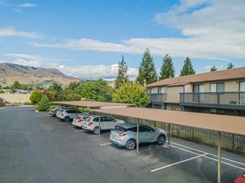 A parking lot with cars parked in front of a hotel building