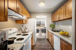 Wenatchee apartment for rent - a kitchen with white appliances and wooden cabinets at Cedarwood, Wenatchee, WA