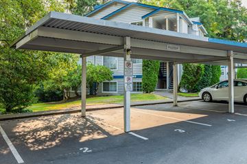 Edmonds apartment for rent - A parking lot with a car parked under a shelter.
