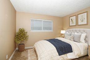 Woodland apartment for rent - a bedroom with a bed and a potted plant