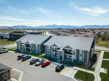 An aerial view of a building with cars parked in a parking lot