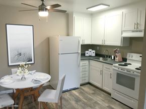 Woodland apartment for rent - a small kitchen with white appliances and a white table and chairs at Woodland Crossing , Woodland California