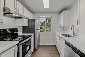 Fife apartment for rent - A kitchen with white cabinets and black appliances.