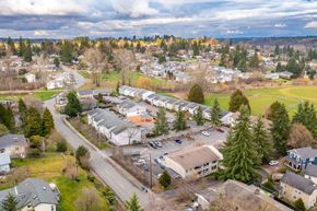 Snohomish apartment for rent - Aerial view of the community with trees along the skyline, houses, and large grass fields in the surrounding area.at The Trail, Snohomish, WA